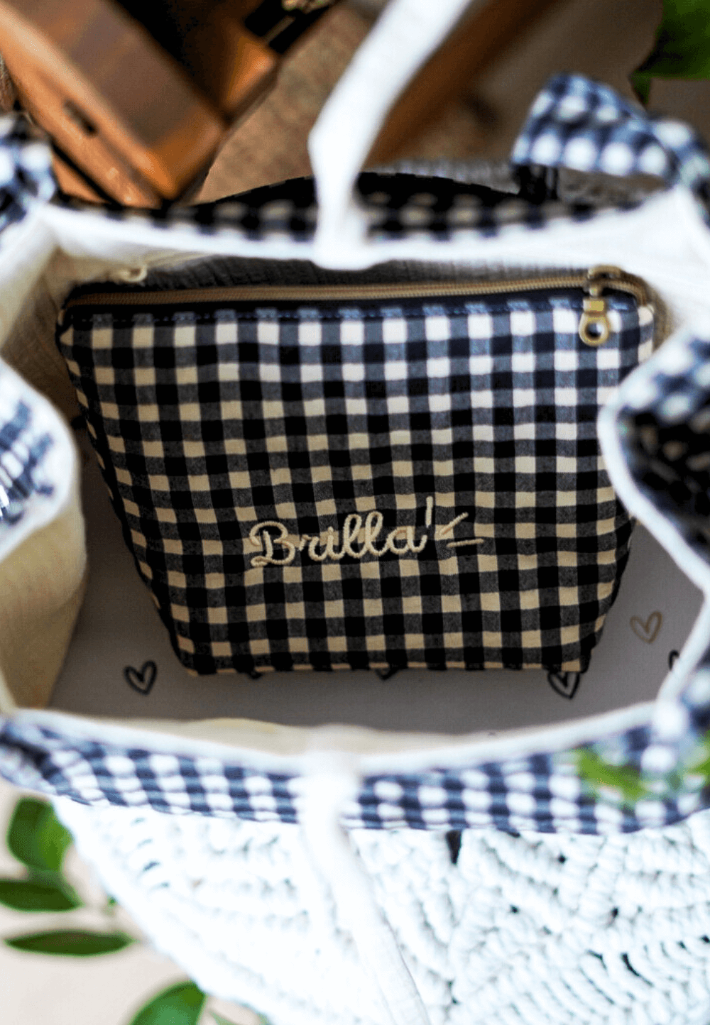 Pequeño neceser Black Vichy con el nombre "Brilla" dentro de un bolso, ideal para maquillaje y artículos de higiene.