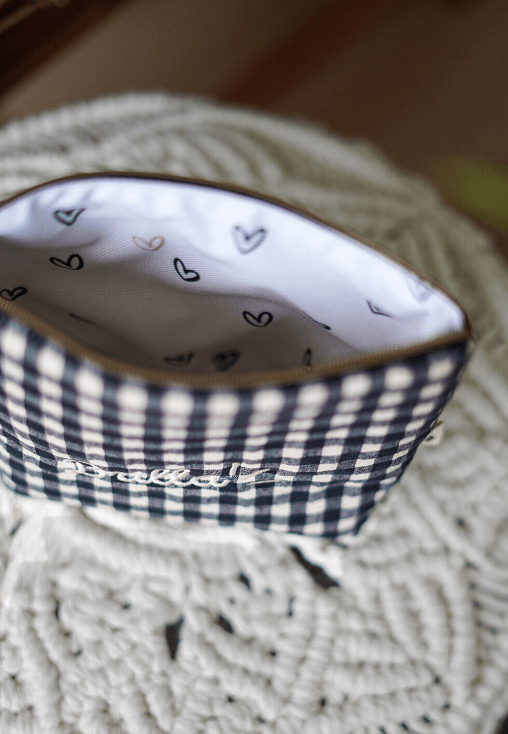 bolsa de maquillaje impermeable con interior estampado de corazoncitos y exterior tela vichy negro